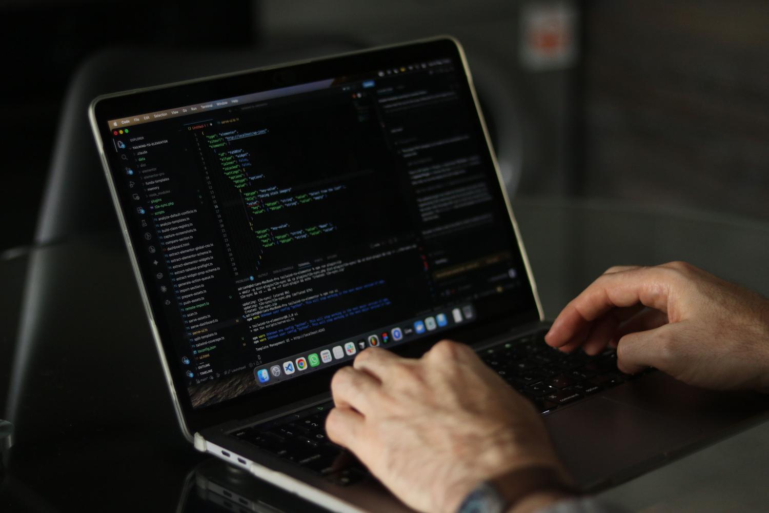 Manos de un programador escribiendo código en un portátil con una ventana de terminal abierta, representando el uso de herramientas CLI como Aider.
