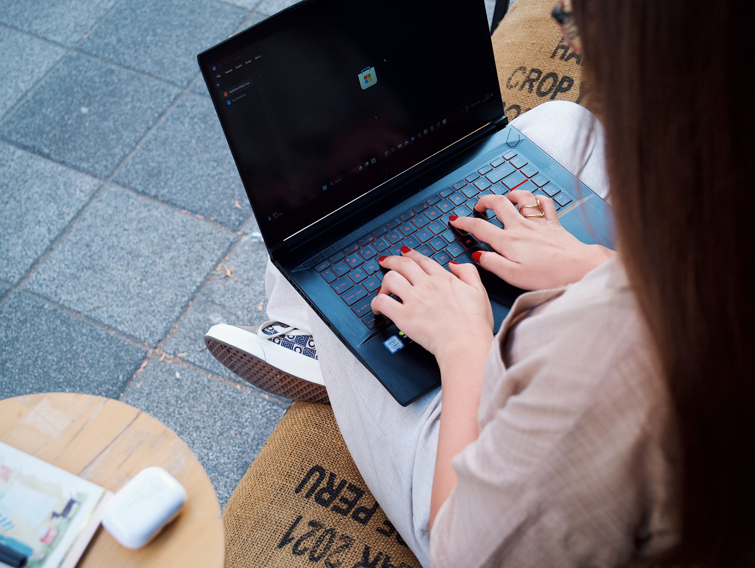 Mujer trabajando con una laptop en el exterior, ilustrando la libertad de acceder a SFTPGo desde cualquier parte del mundo mediante Tailscale.
