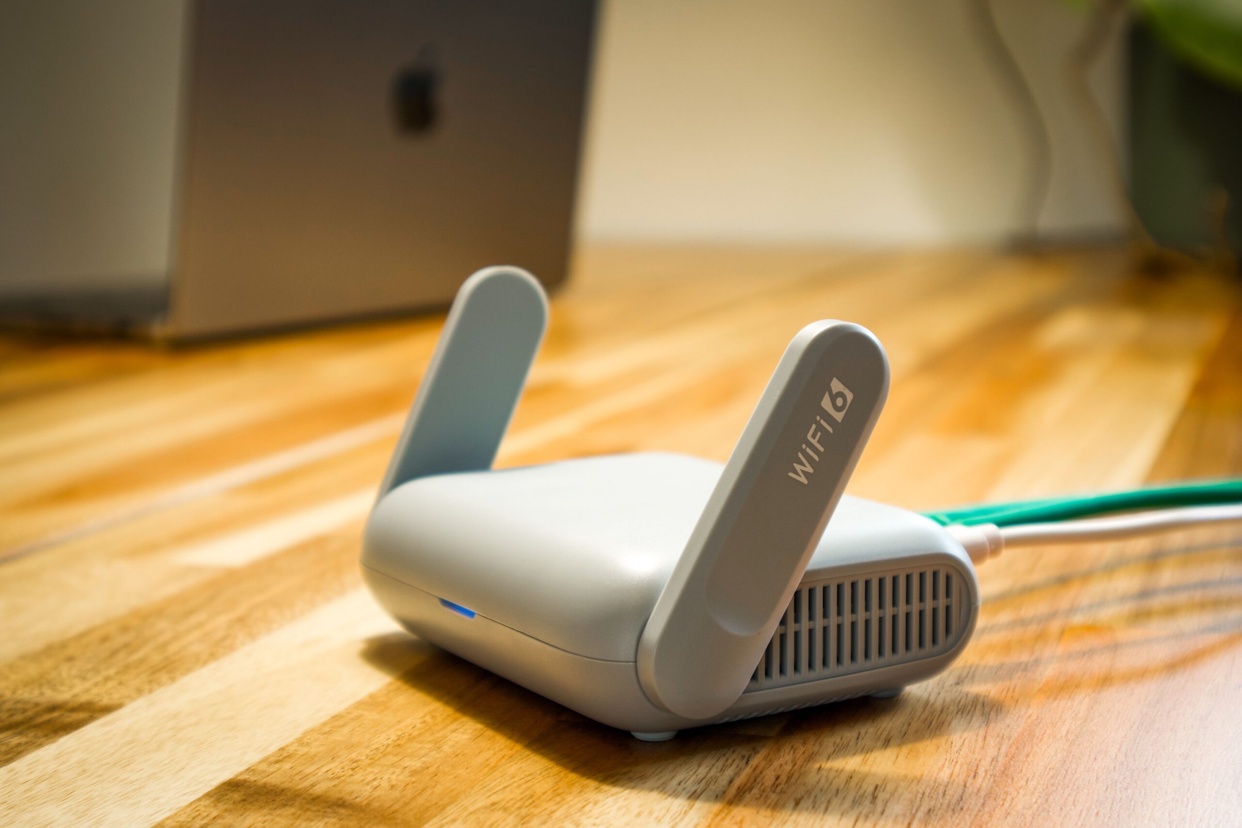 Router WiFi moderno sobre un escritorio de madera, punto clave para la configuración del DNS en la red familiar.