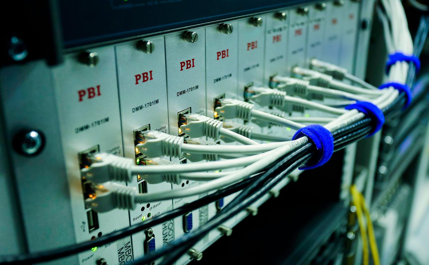 Detalle de cables de red conectados a un switch, representando la configuración de URIs y conectividad entre contenedores.