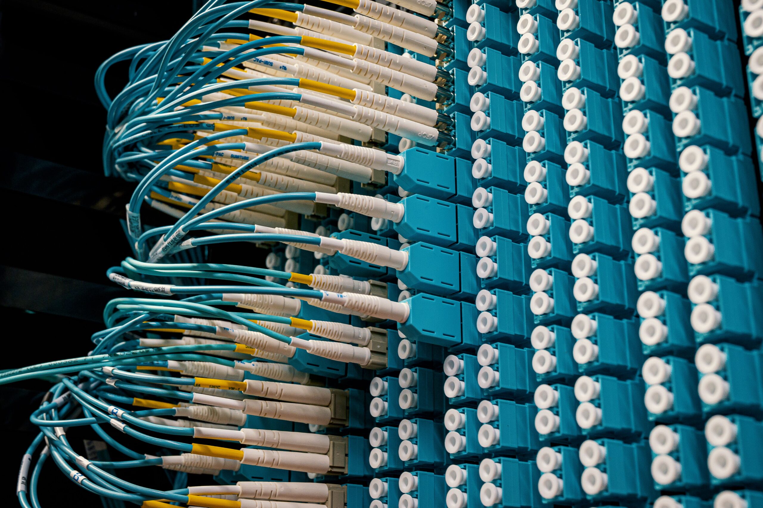 Primer plano de cables de fibra óptica conectados a un panel de parcheo en un centro de datos, ilustrando la infraestructura física donde reside el servidor MCP.