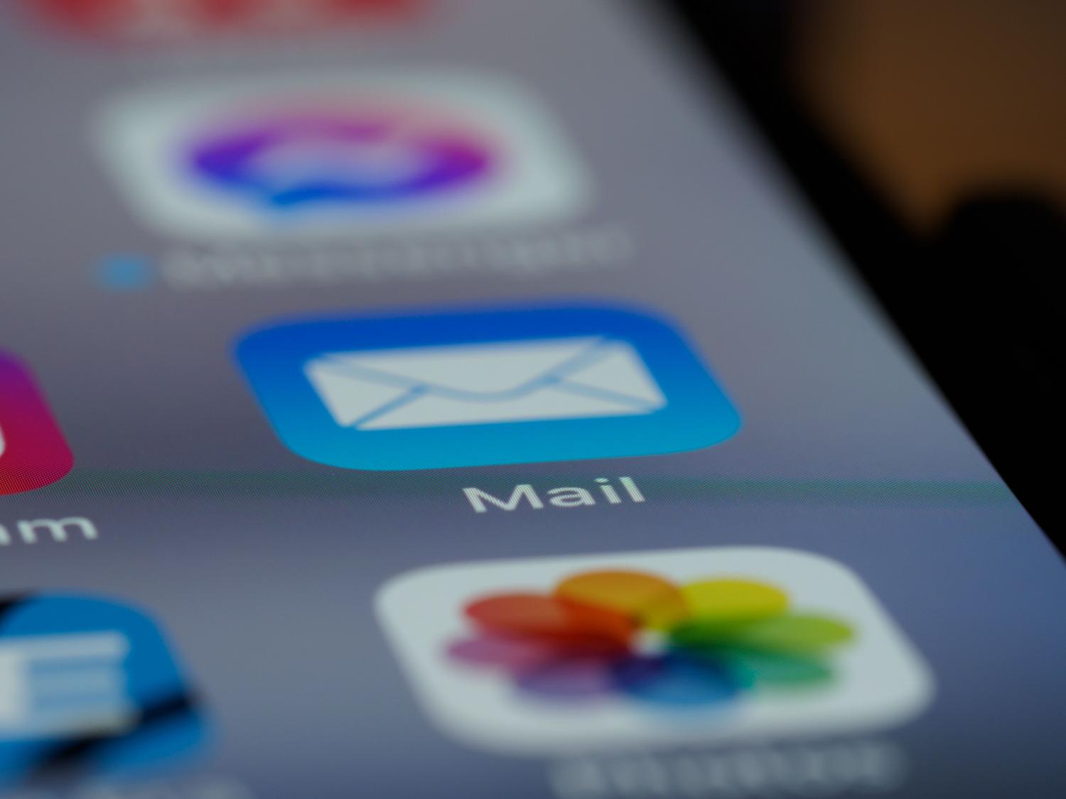 Detalle de la aplicación de correo electrónico en la pantalla de un smartphone, representando la configuración del SMTP para el envío de notificaciones y recuperación de cuentas.