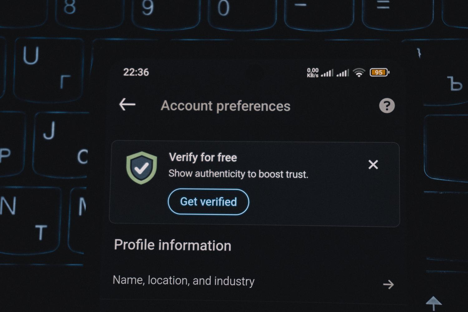 Primer plano de un smartphone con una alerta de verificación de cuenta, ilustrando la gestión de identidades y MFA.