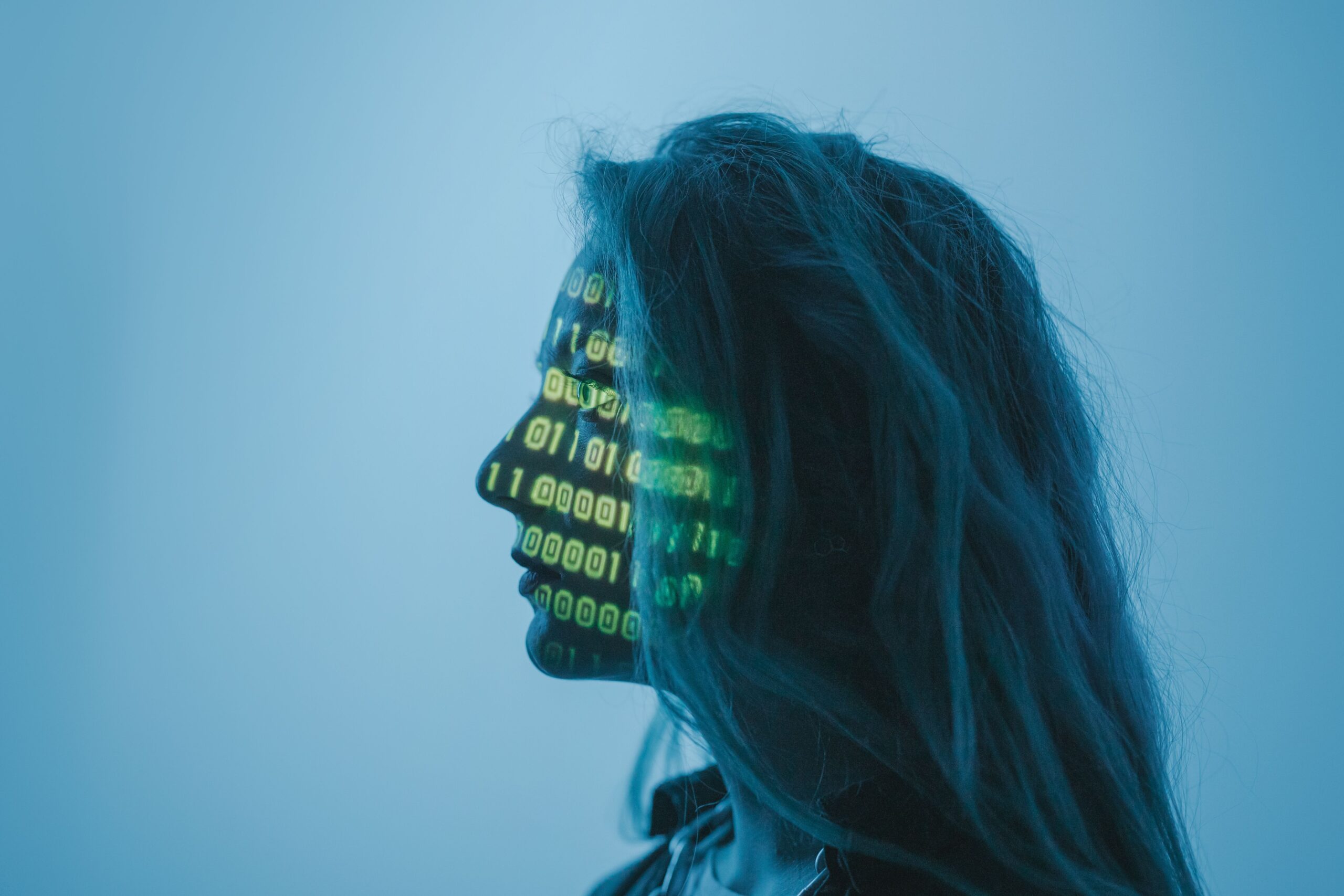 Representación conceptual de la IA procesando datos con código binario proyectado sobre un rostro humano.