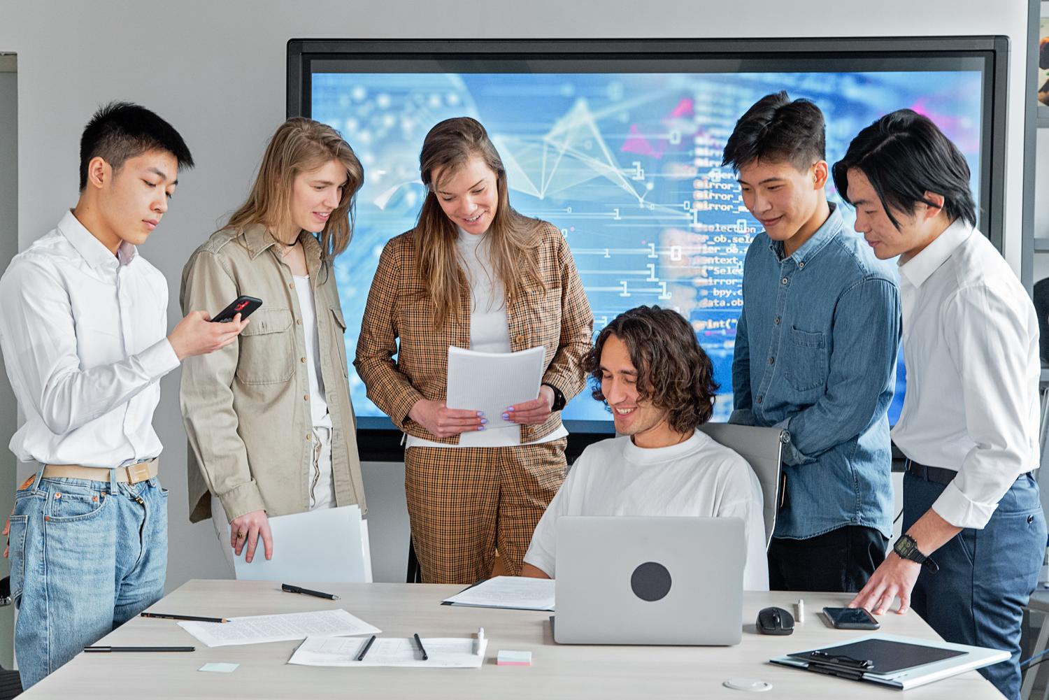 Grupo de trabajo multidisciplinar coordinando tareas en un entorno de oficina contemporáneo.