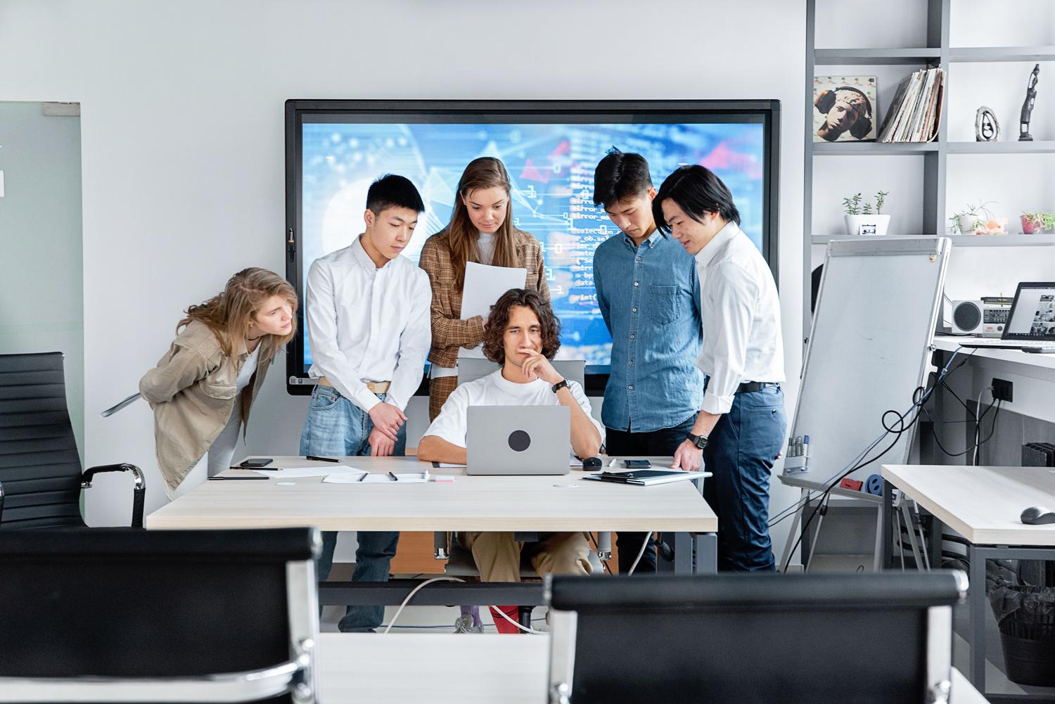 Desarrolladores de software trabajando juntos en un proyecto técnico en una oficina moderna.