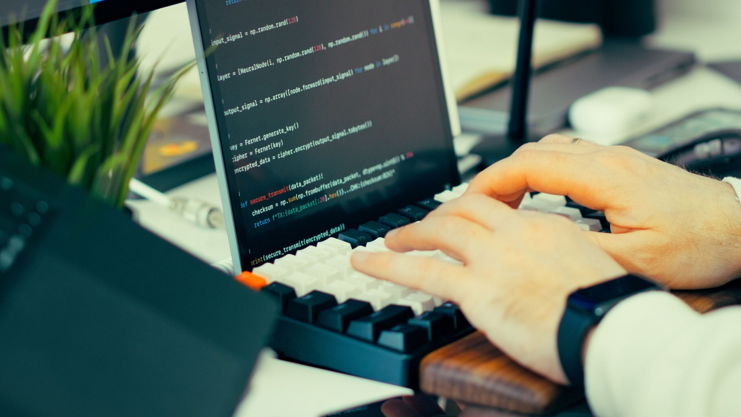 Primer plano de un desarrollador escribiendo código en un teclado, ilustrando la instalación avanzada de software mediante terminal.