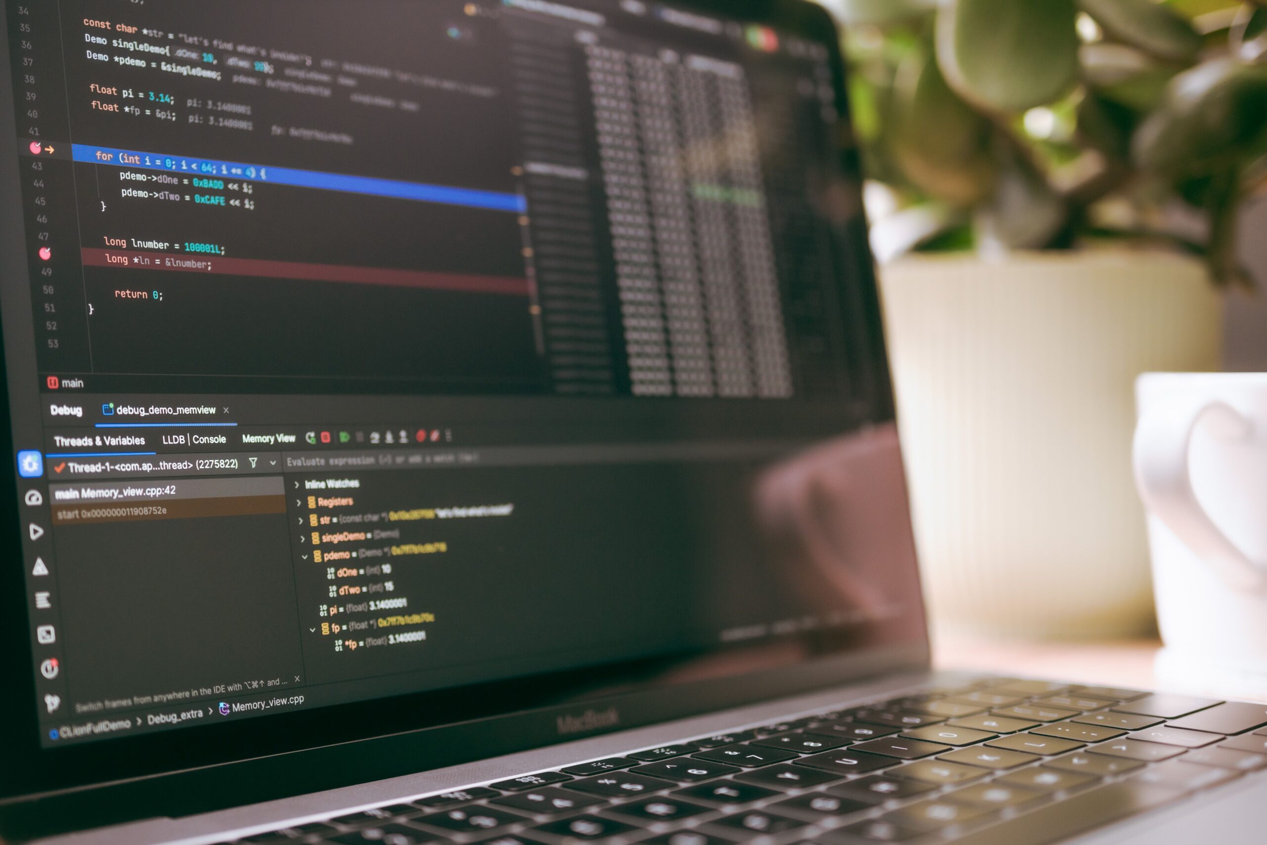 Primer plano de una pantalla de portátil mostrando un editor de código y herramientas de depuración.