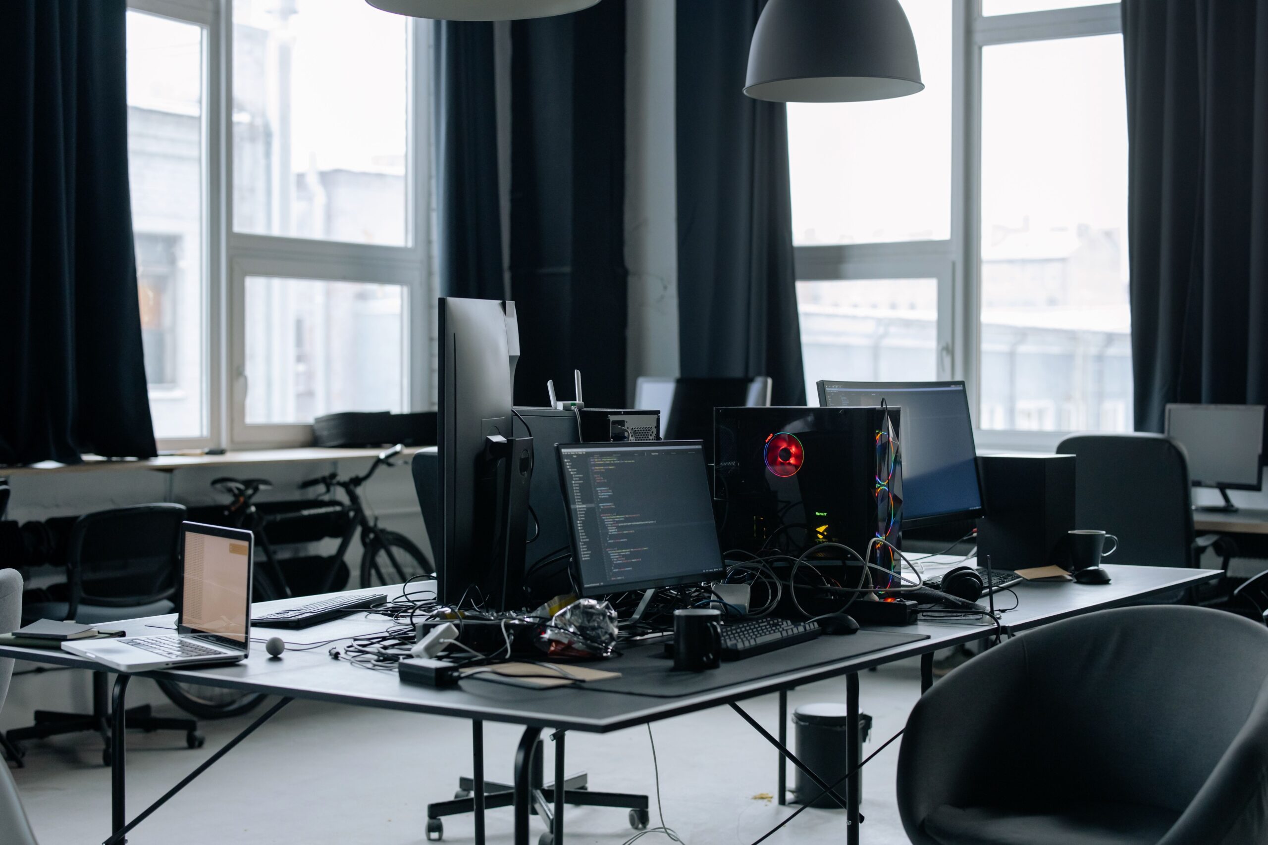 Espacio de trabajo contemporáneo con múltiples pantallas y hardware avanzado para desarrollo de software.