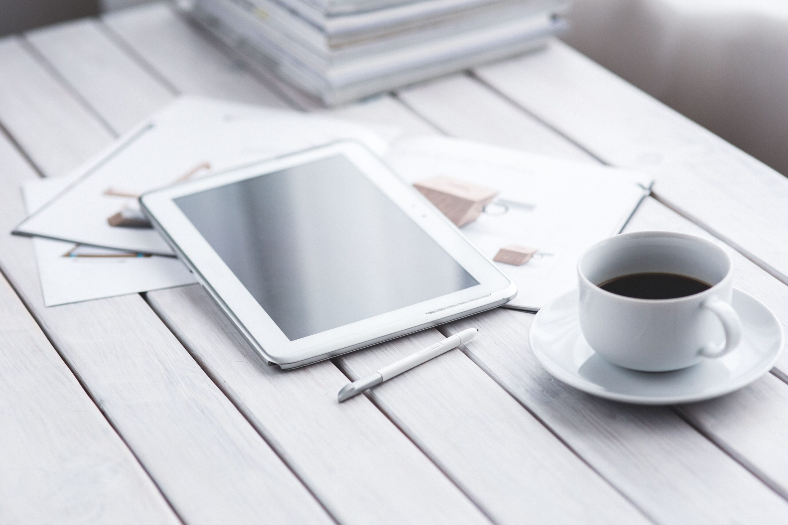Tableta digital y café en un escritorio, evocando la lectura cómoda de artículos guardados.