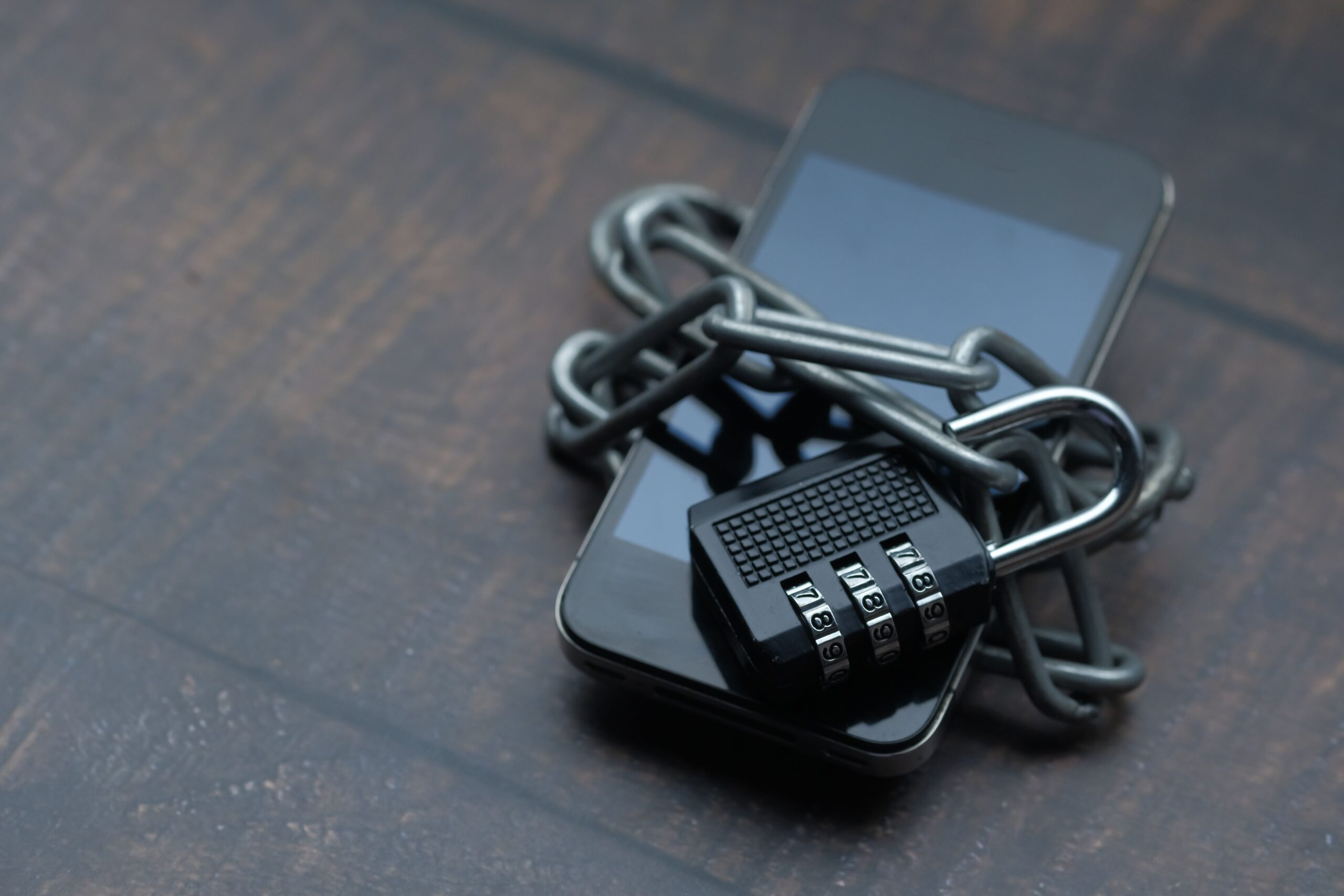 Smartphone envuelto en una cadena con un candado, representando el bloqueo de accesos públicos para asegurar el uso exclusivo del bot.