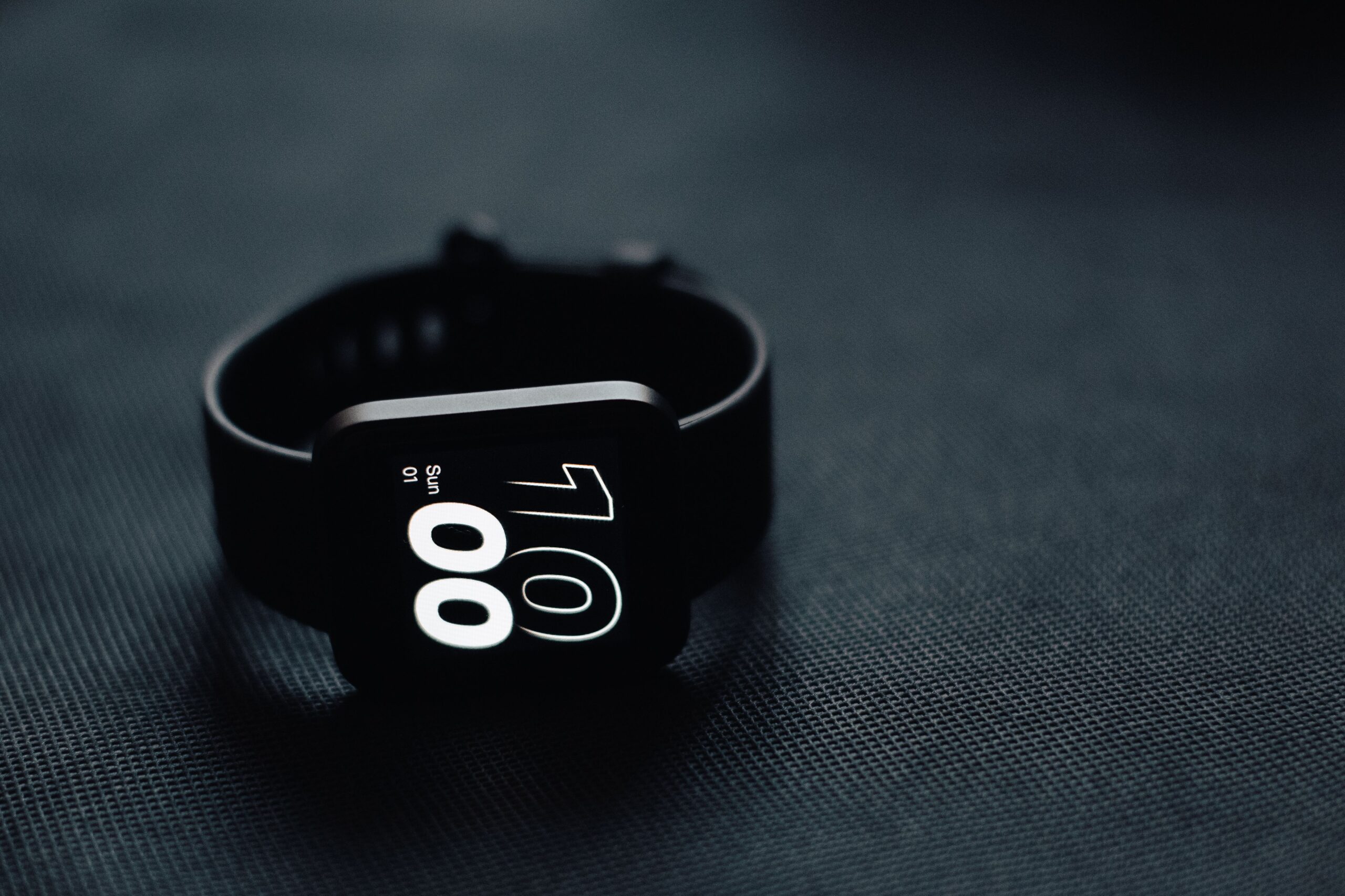 Primer plano de un reloj inteligente moderno sobre una superficie oscura, representando la tecnología de gestión de datos.