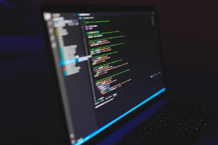 Laptop displaying code in a dark environment, representing a developer's workspace for WSL and Docker.