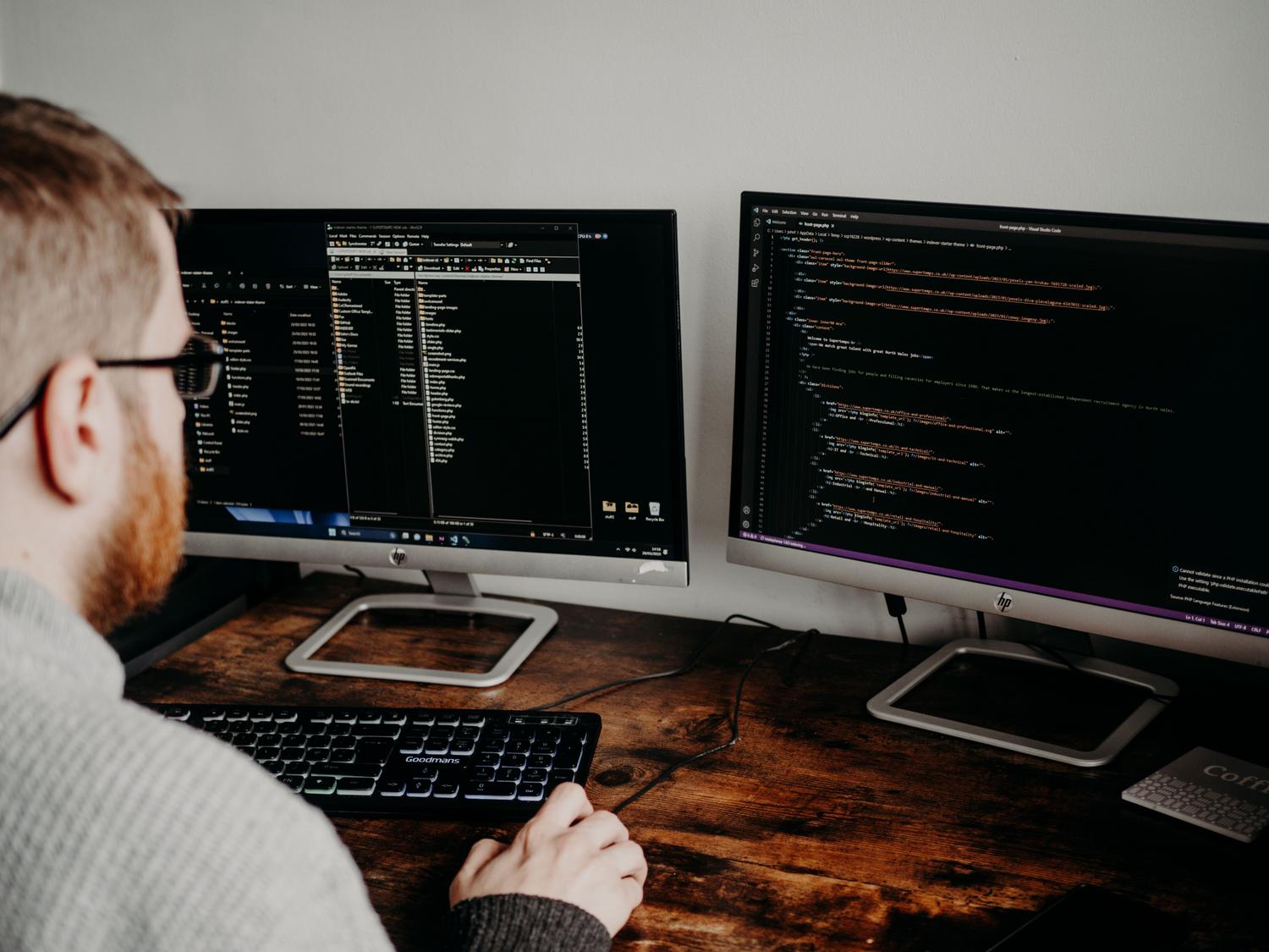 Desarrollador de software trabajando en su oficina en casa con monitores duales, capturando la esencia del control local de la IA.