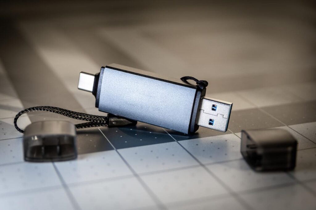 Primer plano detallado de una memoria USB dual con conectores USB-C y USB-A sobre un fondo técnico.