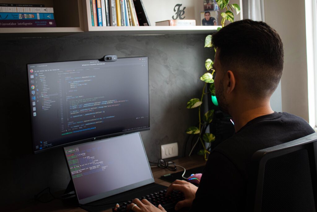 Programador trabajando con doble monitor y terminal visible, ideal para ilustrar un artículo sobre WSL y contenedores en Windows 11