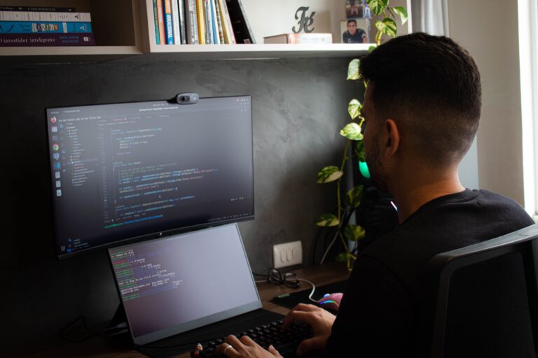 Programador trabajando con doble monitor y terminal visible, ideal para ilustrar un artículo sobre WSL y contenedores en Windows 11