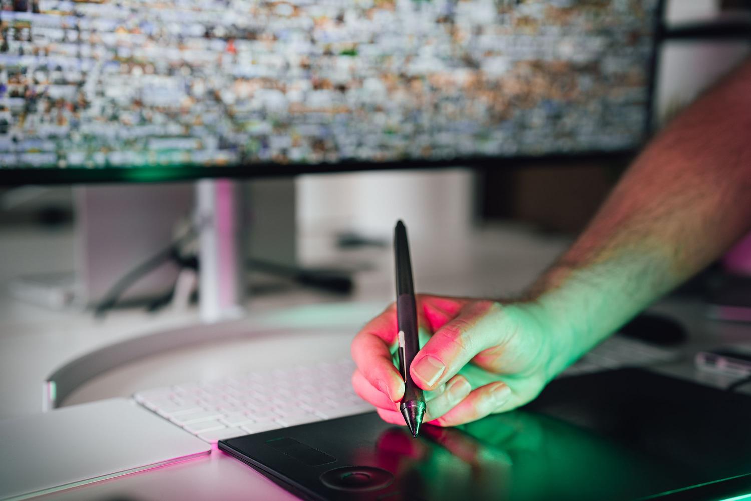 Artista digital trabajando con tableta gráfica y lápiz óptico.