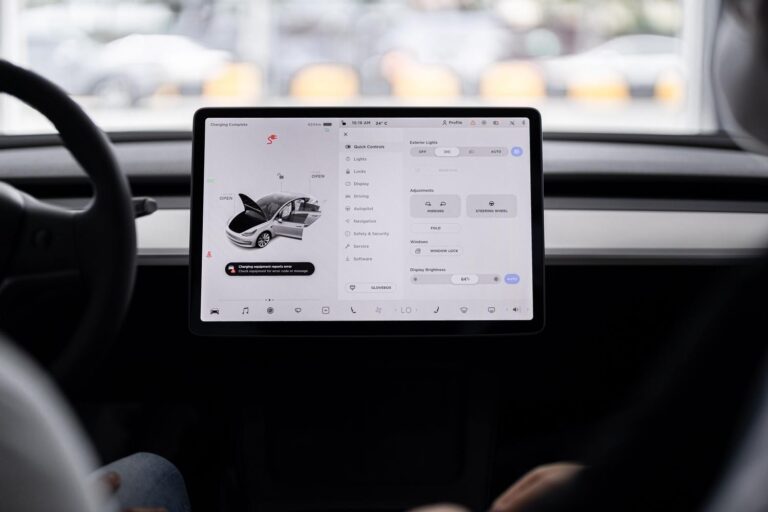 Weitwinkelansicht des Armaturenbretts eines modernen Autos mit einem dominanten zentralen Digitalbildschirm.