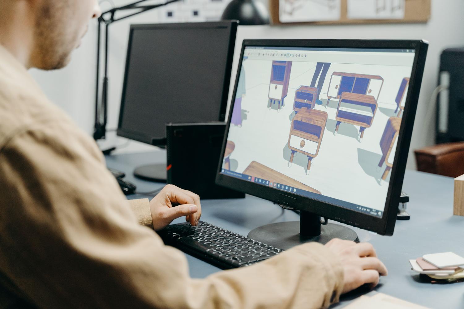 Diseñador utilizando software de modelado 3D en un entorno de oficina profesional.