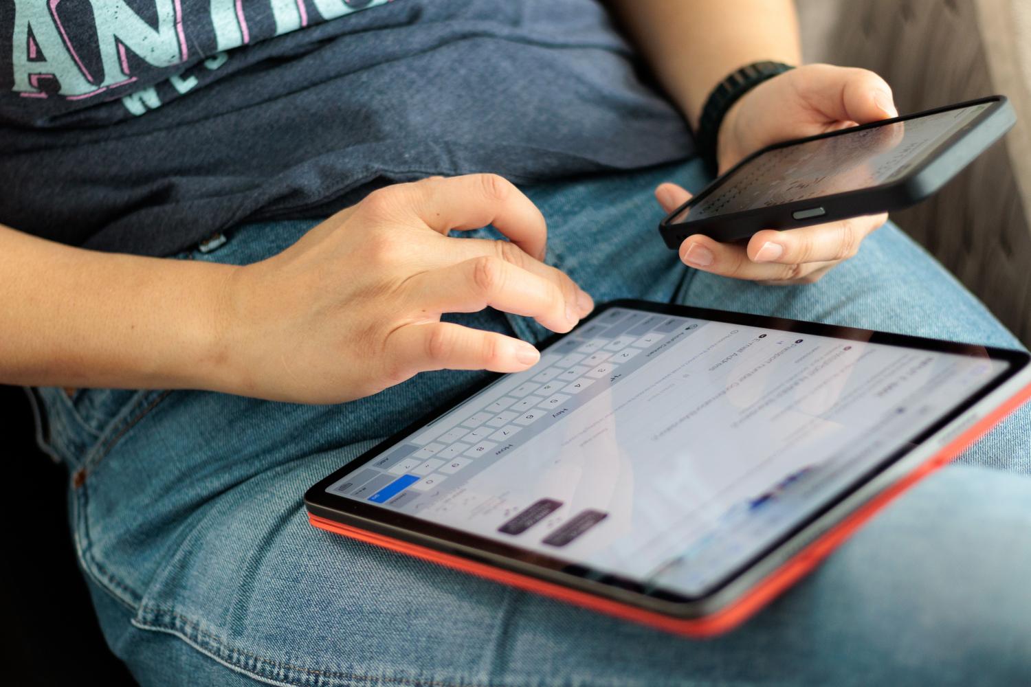 Uso simultáneo de tablet y smartphone representando la conectividad y el ecosistema de dispositivos.