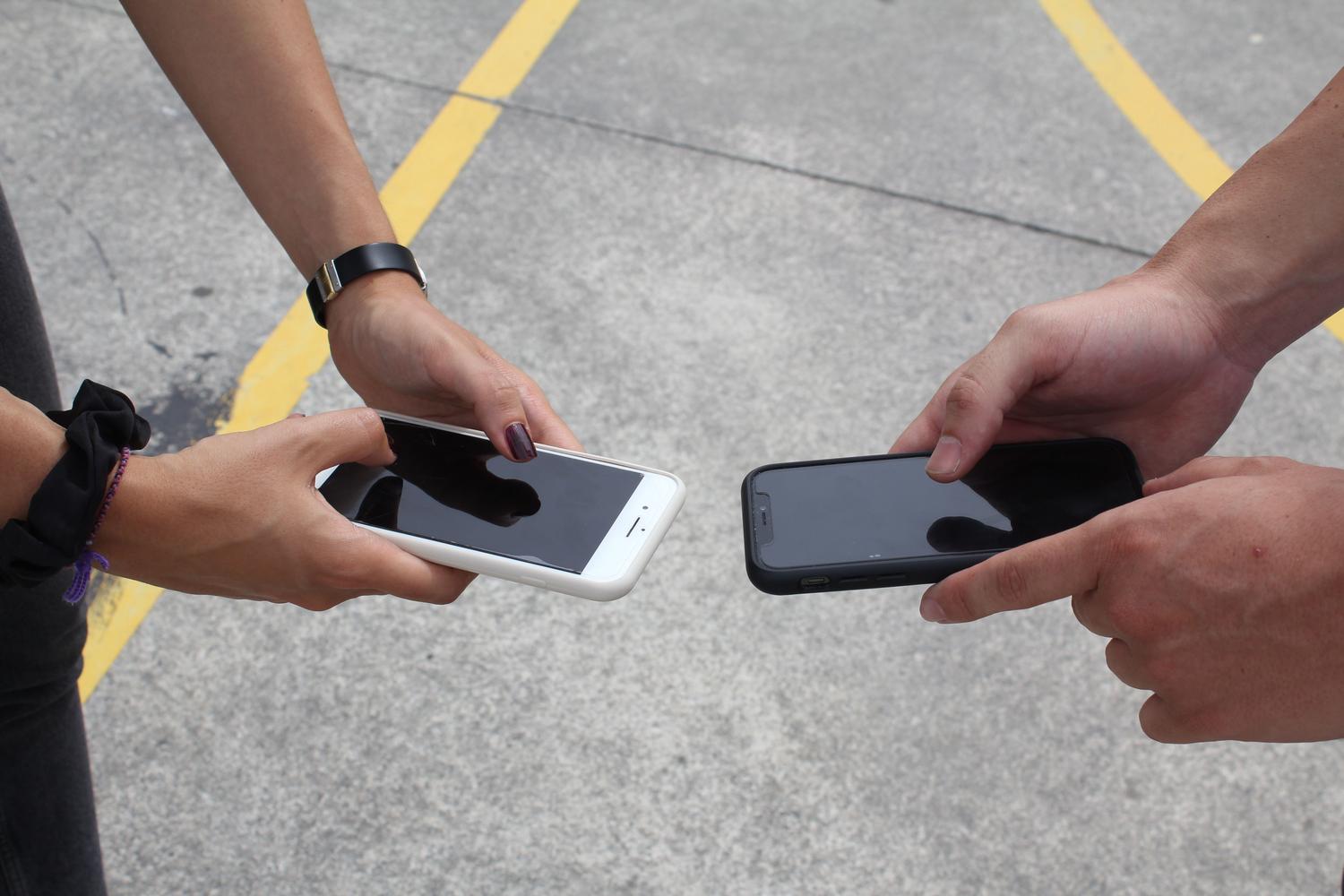 Detalle de dos smartphones interactuando para compartir datos de red