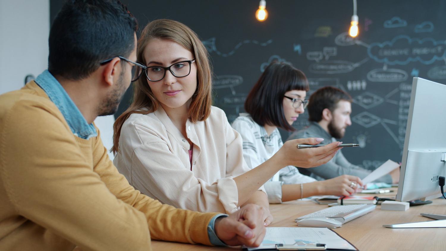 Jóvenes profesionales trabajando en un espacio creativo y moderno, representando la productividad y el flujo de trabajo optimizado.