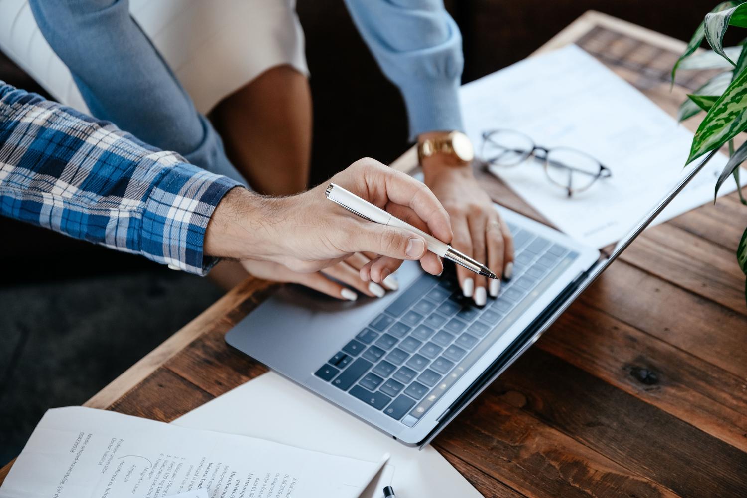 Vista cenital de compañeros de trabajo revisando información en un portátil, evocando el hallazgo de datos críticos en conversaciones. Vista cenital de compañeros de trabajo revisando información en un portátil, evocando el hallazgo de datos críticos en conversaciones.