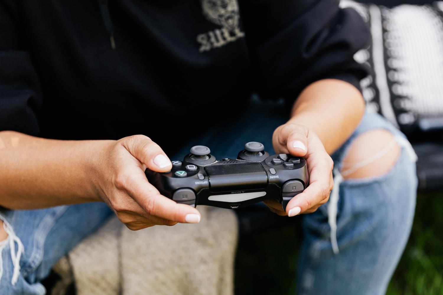 Persona sosteniendo un mando de videojuegos en una postura relajada, transmitiendo la experiencia de juego inmersivo.