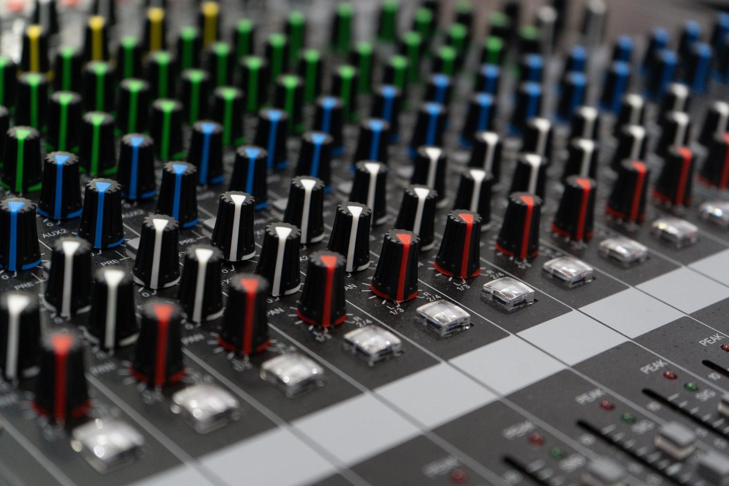 Consola de mezcla de audio profesional con diales de colores, utilizada como metáfora visual de la capacidad de mezclar volúmenes de aplicaciones independientes.