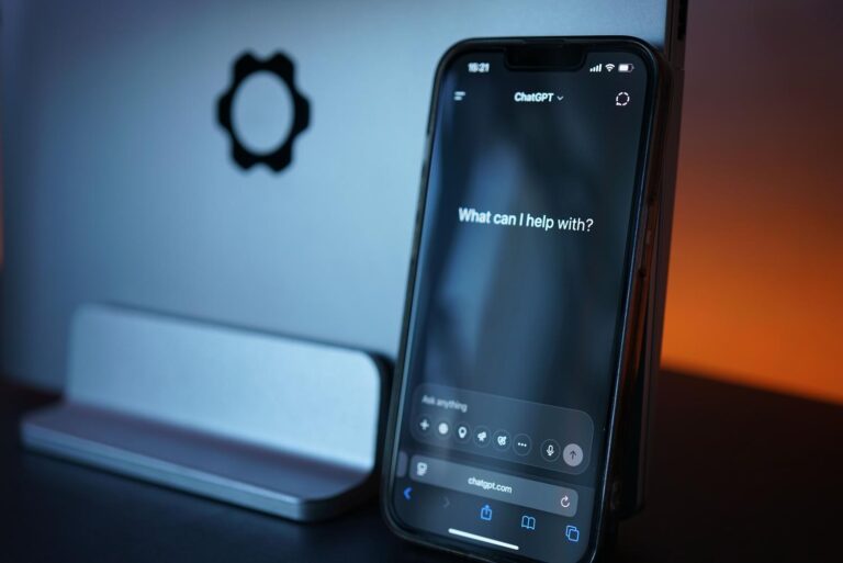 Interfaz de chat de inteligencia artificial en un smartphone y portátil, representando la interacción con asistentes virtuales.