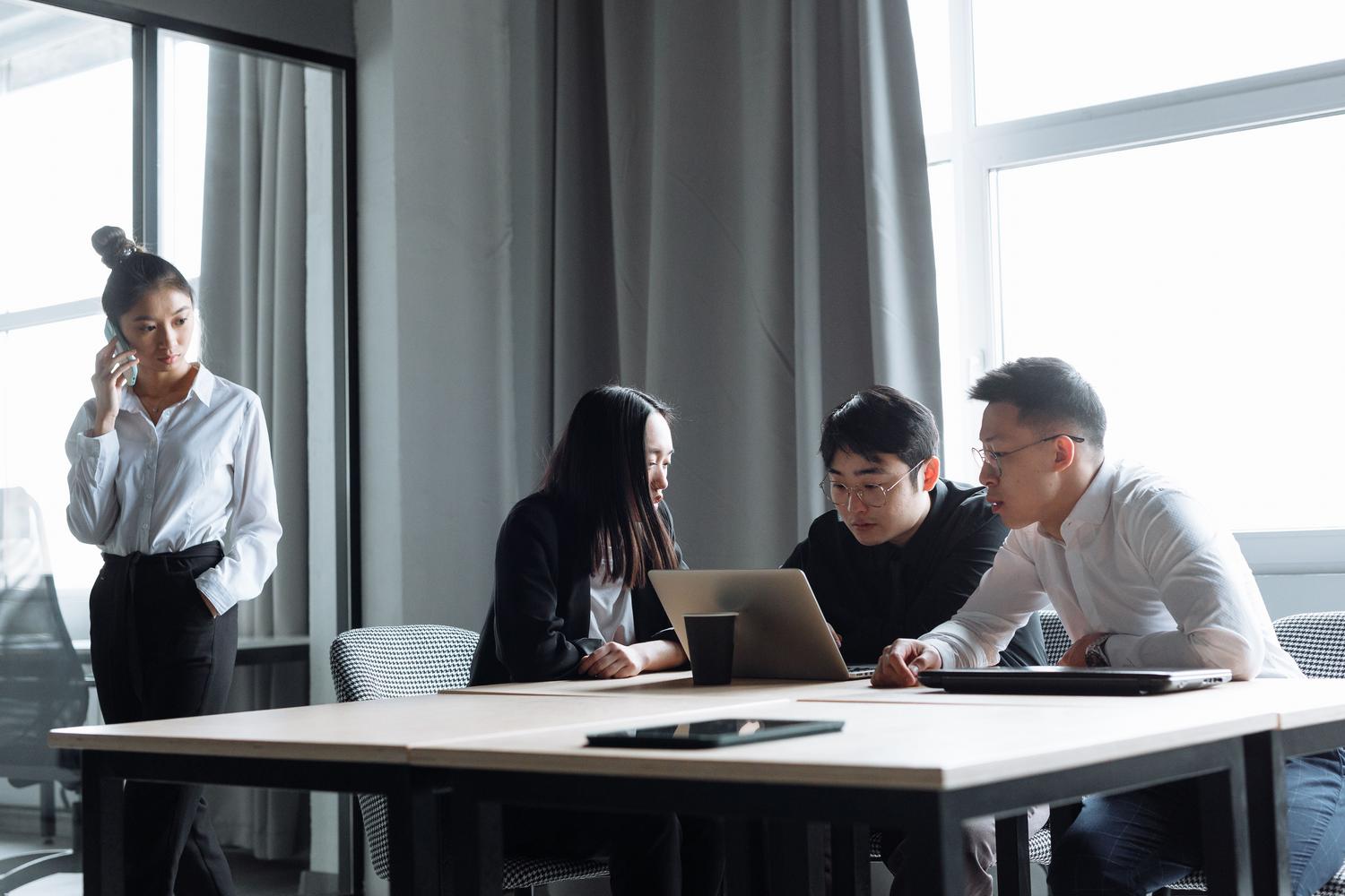 Une équipe de professionnels collaborant devant un ordinateur dans un bureau moderne, symbolisant la mise en œuvre d'outils technologiques.