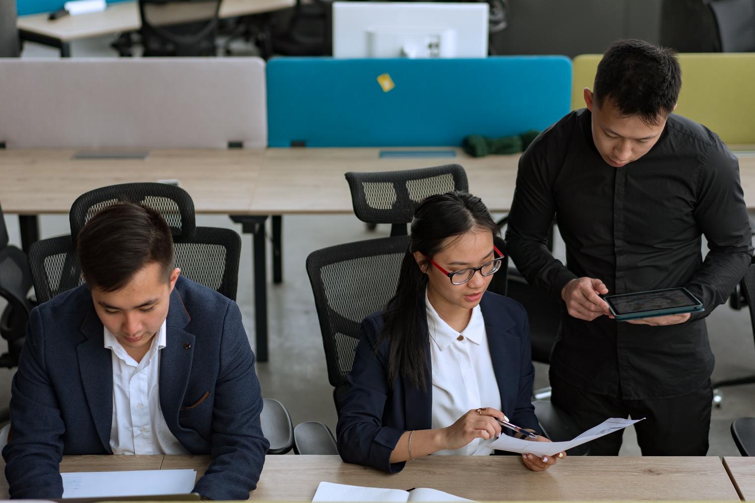 Des professionnels discutent, dans un bureau moderne, de stratégie d'entreprise et d'utilisation des technologies.