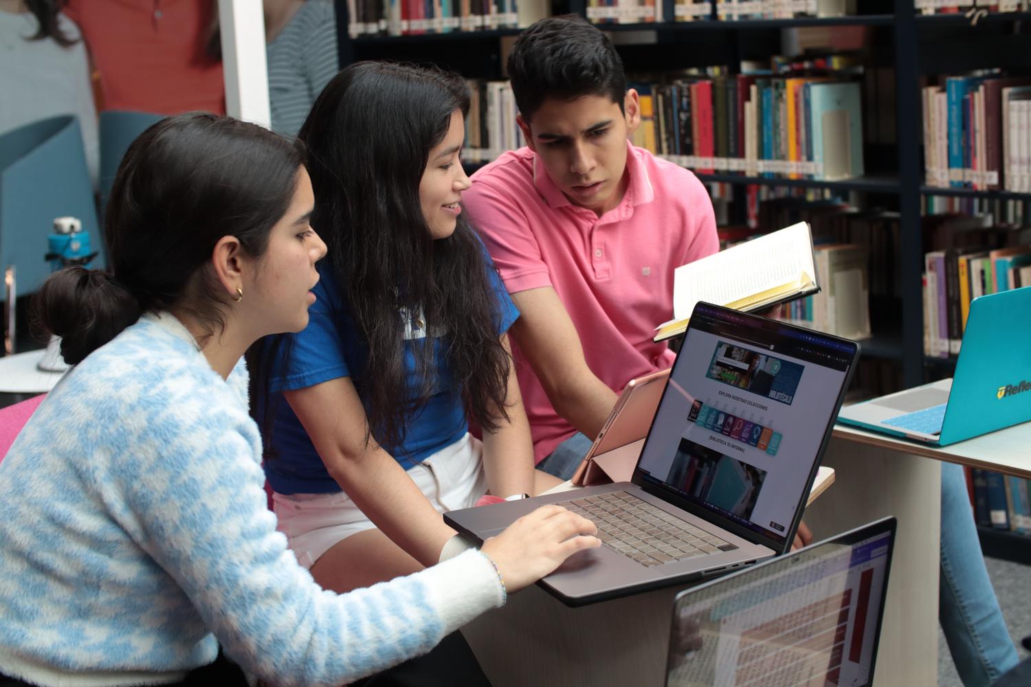 Grupo de estudiantes estudiando en una biblioteca, evocando la organización de fuentes de conocimiento en un cuaderno inteligente.