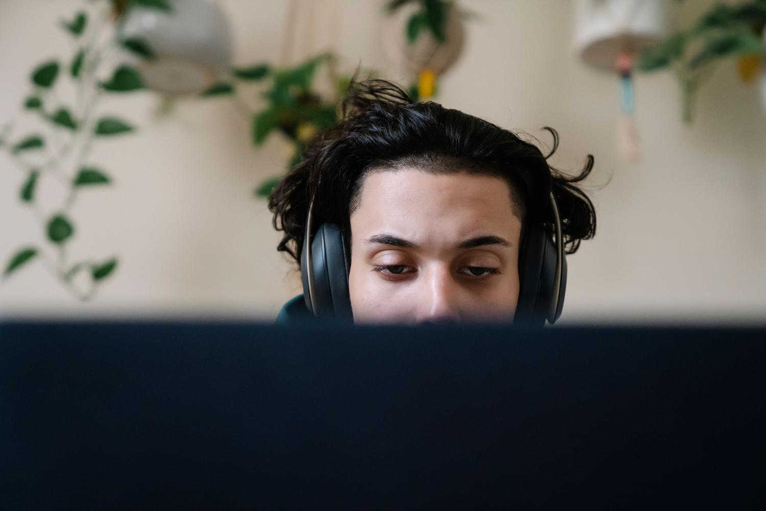 Joven concentrado con auriculares, ilustrando el uso de resúmenes de audio y podcasts para el repaso.