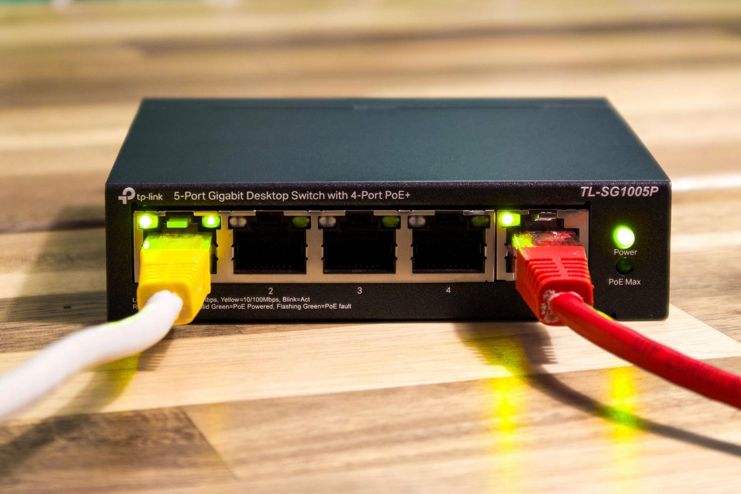 Close-up of an ethernet switch with connected cables, representing technical network segmentation and VLANs.