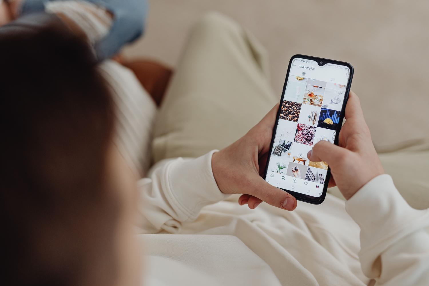 Primer plano de una persona navegando por el feed de Instagram en un smartphone