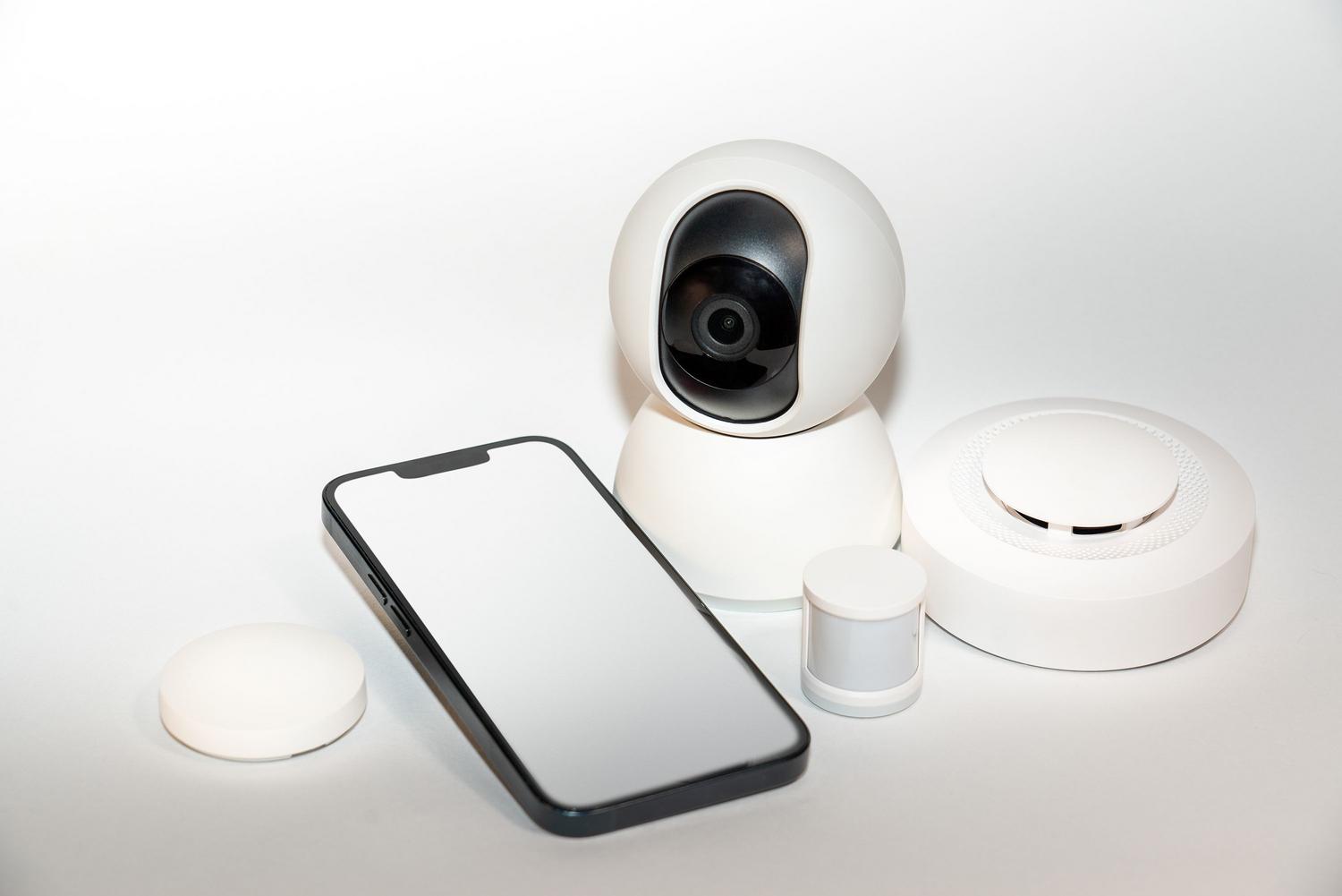 Conjunto de dispositivos de seguridad inteligente y un smartphone, ilustrando la gestión de alertas de detección.