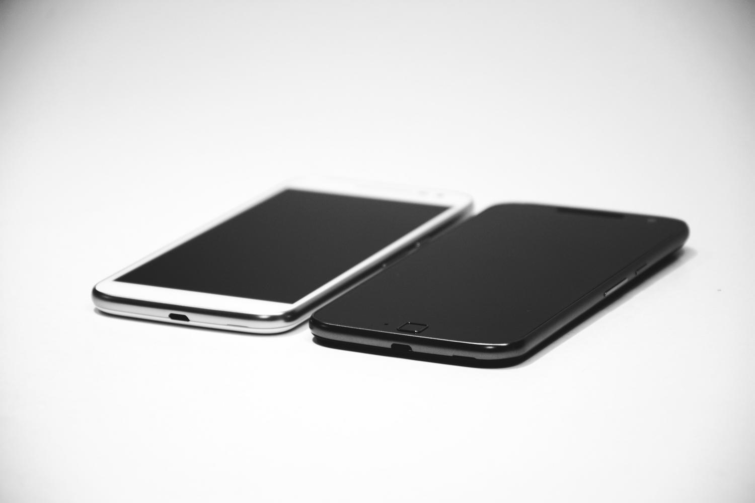 Dos teléfonos móviles en blanco y negro sobre una superficie neutra, representando la estética monocromática del sistema Nothing OS.