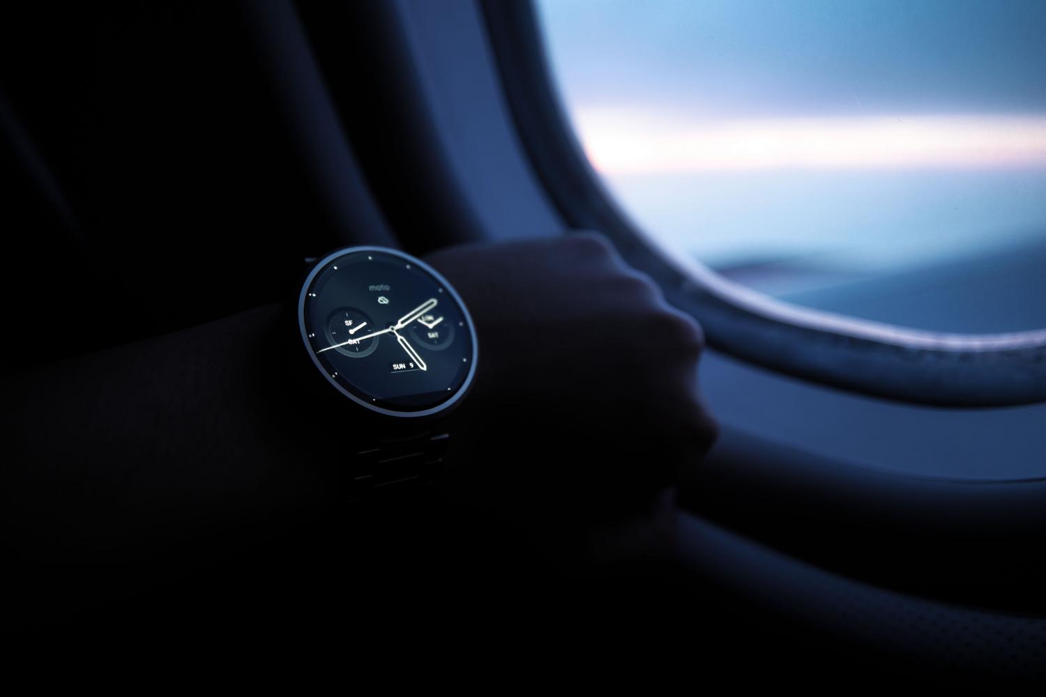 Primer plano de un reloj inteligente en la muñeca de una persona frente a la ventana de un avión, ilustrando el concepto de uso de aplicaciones sin conexión a Internet.