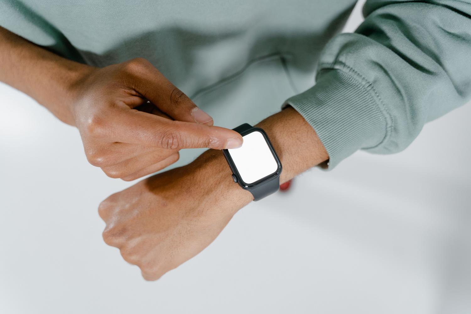 Detalle de una persona utilizando la interfaz de un reloj inteligente, ideal para ilustrar los pasos de configuración y ajustes.