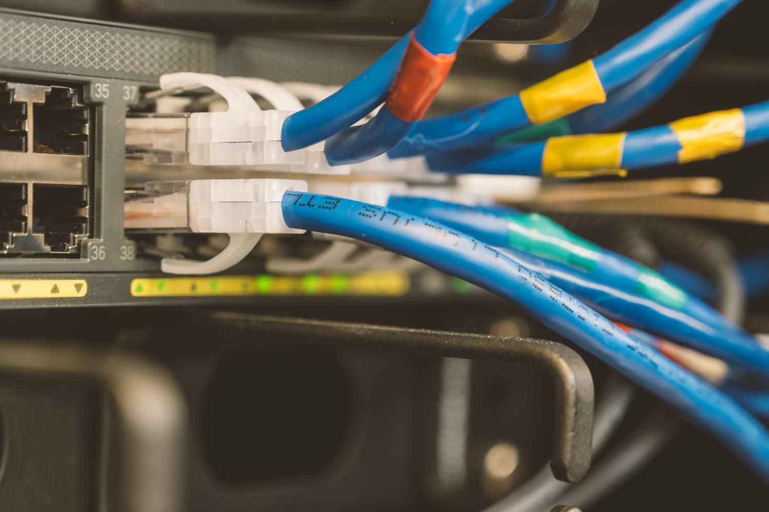 Cable Ethernet conectado a un switch de red, fundamental para reducir la latencia en el streaming de juegos.