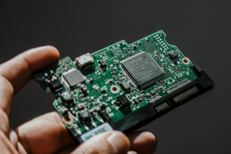 Primer plano de una placa de circuito impreso sostenida por una mano, representando la creación de hardware personalizado con ESPHome.