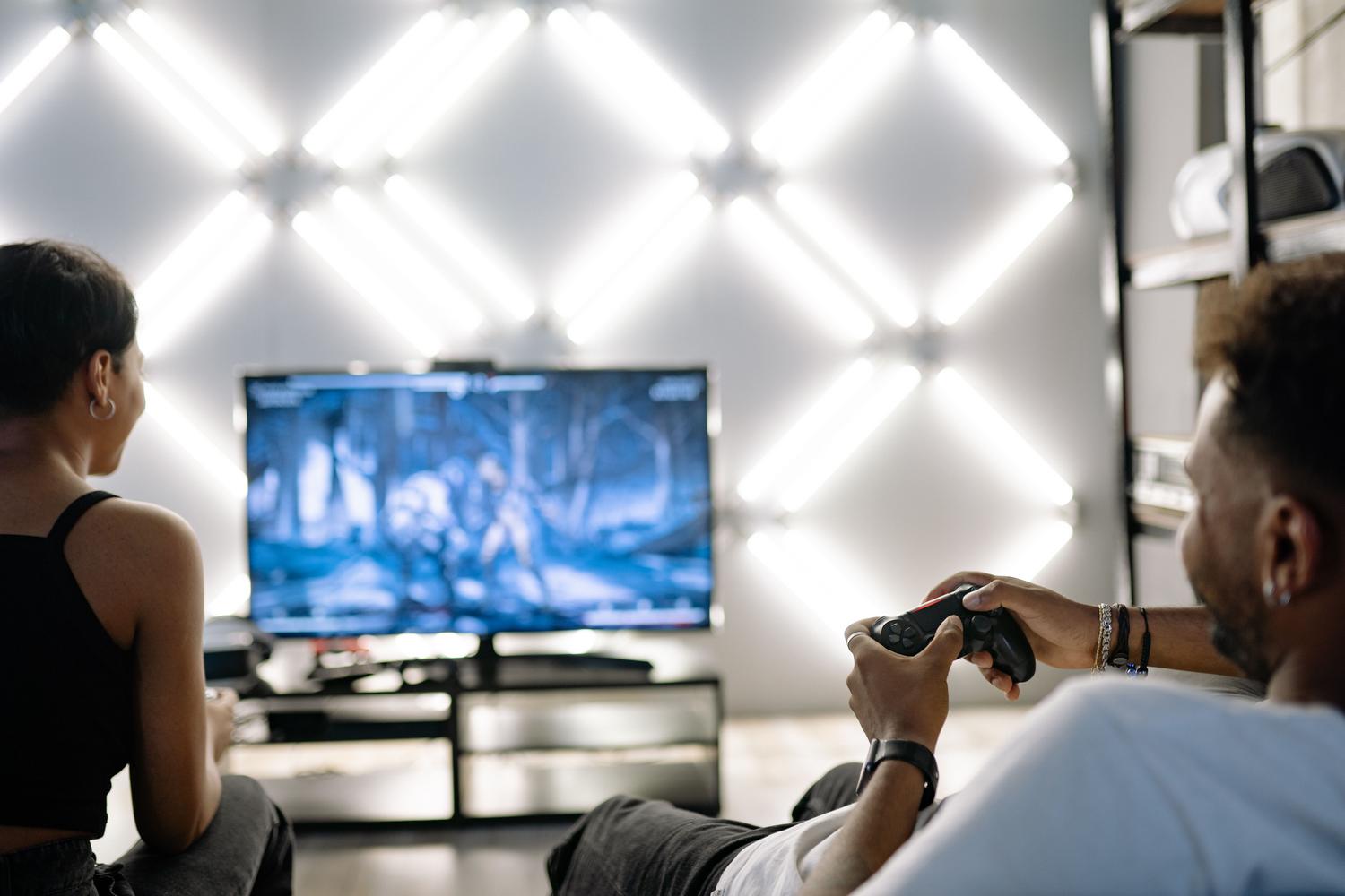 Dos personas compartiendo una experiencia de juego en un salón moderno con luces LED.