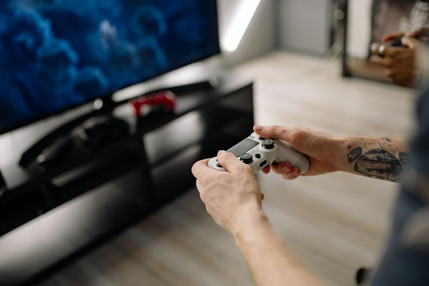 Primer plano de un mando de consola siendo utilizado para jugar en una televisión.