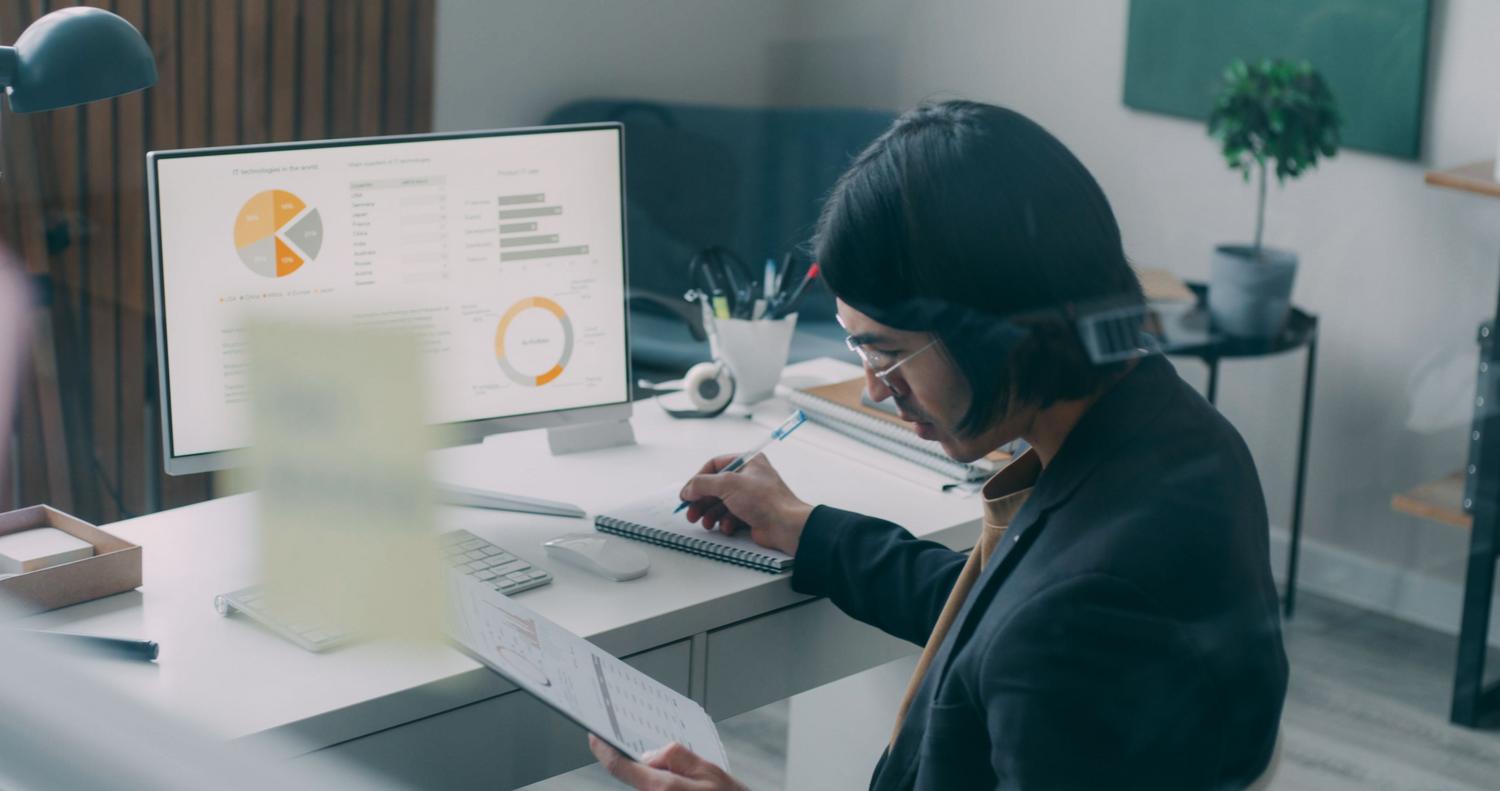 Un profesional analizando datos y gráficos en una pantalla en una oficina moderna, representando el análisis inteligente de información.