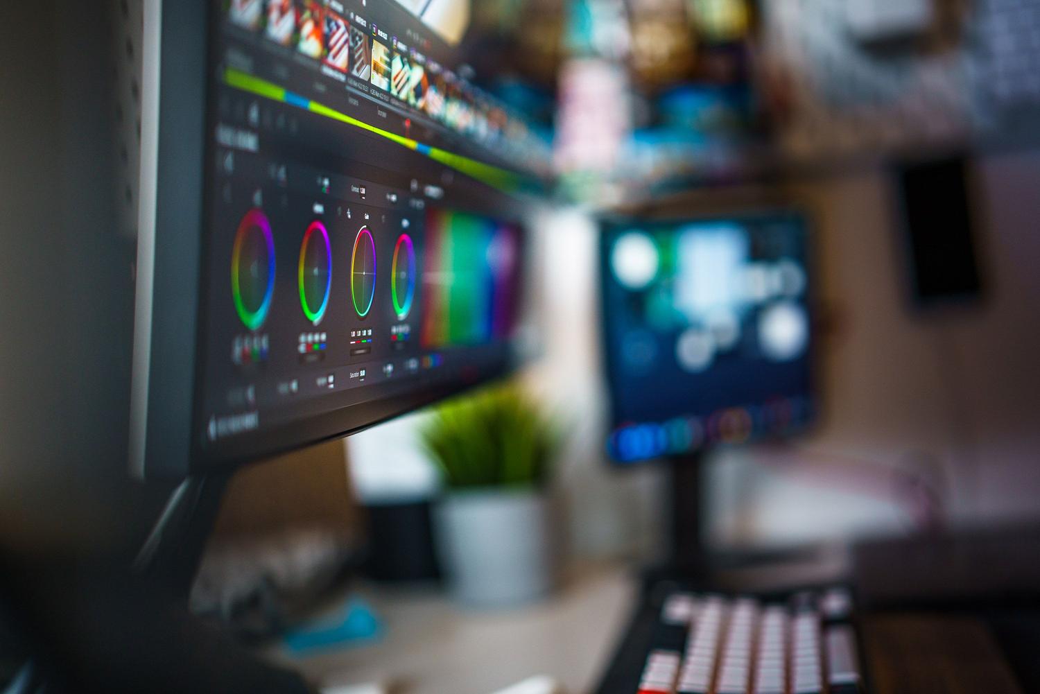 Primer plano de un software de gradación de color profesional en un monitor de alta resolución, mostrando las ruedas de color para ajustes precisos.
