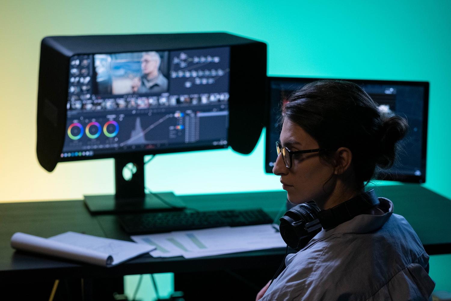 Estación de trabajo de postproducción profesional con un monitor crítico de color equipado con una visera para evitar reflejos y maximizar la fidelidad.