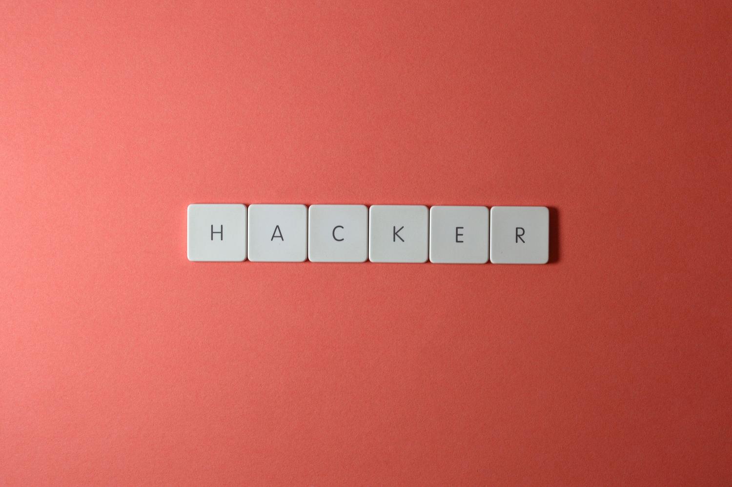 Teclas de teclado formando la palabra HACKER sobre un fondo rojo, simbolizando la amenaza de las filtraciones de datos.