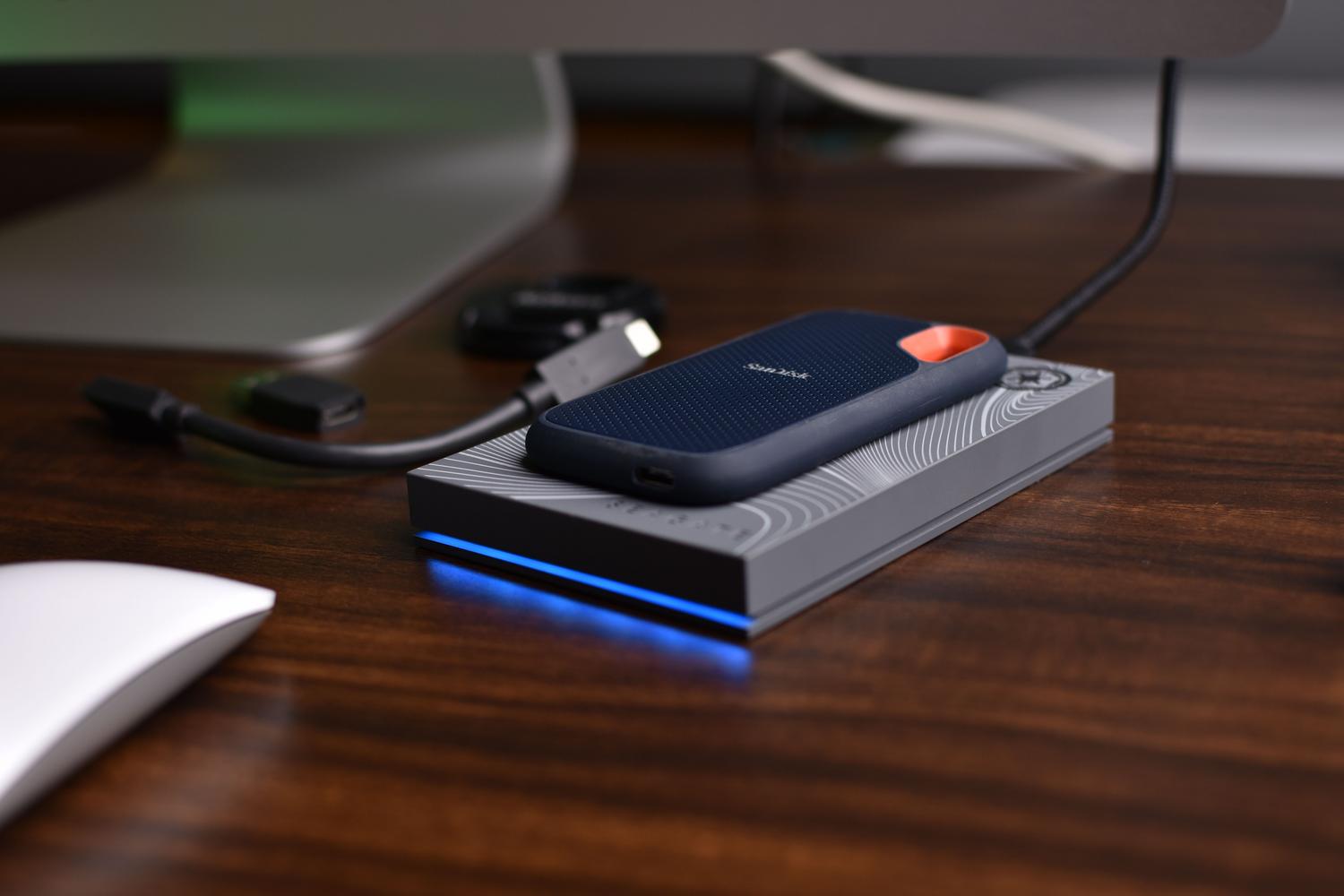Primer plano profesional de un SSD portátil SanDisk con un cable USB-C conectado, resaltando la tecnología de transferencia rápida.